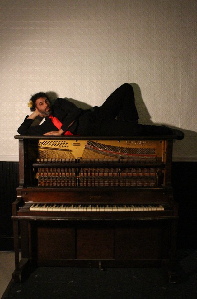 Justin lying on a piano at High Energy Vintage